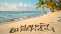 Happy Birthday written in the sand on a beach, with palm trees and the ocean in the background. Royalty Free Stock Photo