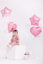 Happy birthday 2 years old little girl in pink dress. white cake with candles and roses. Birthday decorations with white and pink Royalty Free Stock Photo