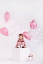 Happy birthday 2 years old little girl in pink dress. white cake with candles and roses. Birthday decorations with white and pink Royalty Free Stock Photo