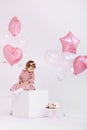 Happy birthday 2 years old little girl in pink dress. white cake with candles and roses. Birthday decorations with white and pink Royalty Free Stock Photo