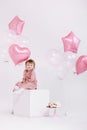 happy birthday 2 years old little girl in pink dress. white cake with candles and roses. Birthday decorations with white Royalty Free Stock Photo