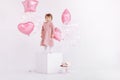 Happy birthday 2 years old little girl in pink dress. white cake with candles and roses. Birthday decorations with white and pink Royalty Free Stock Photo