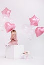 Happy birthday 2 years old little girl in pink dress. white cake with candles and roses. Birthday decorations with white and pink Royalty Free Stock Photo