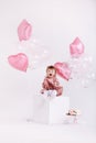 Happy birthday 2 years old little girl in pink dress. white cake with candles and roses. Birthday decorations with white and pink Royalty Free Stock Photo