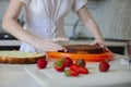 Happy birthday. A young woman is preparing a biscuit for a festive cake. Festive cake decoration. Royalty Free Stock Photo