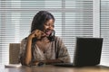 Happy black afro American business woman working cheerful with laptop computer by business district window desk in corporate Royalty Free Stock Photo