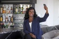 Happy black afro american woman in casual elegant clothes taking selfie portrait photo with mobile phone Royalty Free Stock Photo