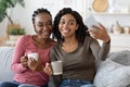 Happy black besties taking selfie on smartphone together at home