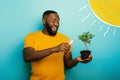 Happy boy watering a small tree ready to be planted. Concept of forestation