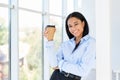 Happy black business woman with cup of coffee in hand during break time in modern office Royalty Free Stock Photo