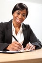 Happy black business woman signing document