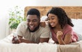 Happy black couple celebrating success, holding smartphone Royalty Free Stock Photo