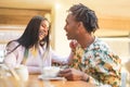 Happy black couple drinking coffee inside vintage bar restaurant - Trendy people having fun talking and laughing at breakfast time Royalty Free Stock Photo