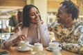 Happy black couple drinking coffee inside vintage bar restaurant - Trendy young people having fun talking and laughing at Royalty Free Stock Photo