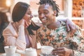 Happy black couple drinking coffee inside vintage bar restaurant - Trendy young people having fun talking and laughing at Royalty Free Stock Photo