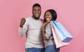 Happy black couple holding shopping bags and smiling