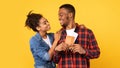 Happy Black Couple Hugging Holding Flight Tickets Over Yellow Background Royalty Free Stock Photo