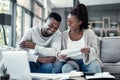 Happy black couple paying bills on a laptop at home, checking their budget and savings. Smiling African american husband Royalty Free Stock Photo