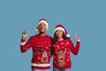 Happy black couple pointing up at copy space, xmas offer