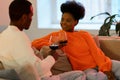 Loving african american couple relaxing at home sit on couch together talking and drinking red wine Royalty Free Stock Photo