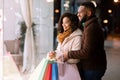 Happy black couple with shopping bags looking at mall window Royalty Free Stock Photo