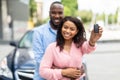 Happy black couple standing near car showing auto keys Royalty Free Stock Photo