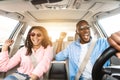 Happy black couple in sunglasses enjoying music driving luxury car Royalty Free Stock Photo