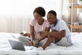 Happy black couple watching movie on laptop in bed Royalty Free Stock Photo