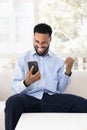 Happy Black customer man receiving good news on mobile phone Royalty Free Stock Photo
