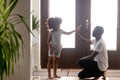 Happy black dad and little daughter giving high-five in hallway Royalty Free Stock Photo