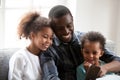 Happy black dad play on smartphone with little daughters Royalty Free Stock Photo