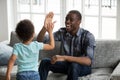 Happy black dad and son giving high-five playing at home Royalty Free Stock Photo