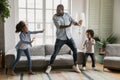 Happy black dad teaching kids to dance at home