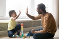 Happy black dad and toddler son giving high-five playing together Royalty Free Stock Photo