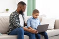 Happy Black Daddy Teaching Kid Son Use Laptop At Home