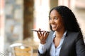 Happy black executive dictating message on phone