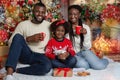 Happy black family celebrating Christmas together at home, drinking milk Royalty Free Stock Photo
