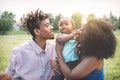 Happy black family enjoying a tender moment during the weekend outdoor - Mother and father having fun with their daughter