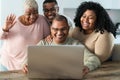 Happy black family having fun doing video call using laptop at home during corona virus outbreak Royalty Free Stock Photo