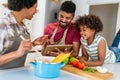 Happy black family in the kitchen having fun and cooking together. Healthy food at home. Royalty Free Stock Photo