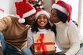 Happy black family in santa claus hats kissing, celebrating xmas Royalty Free Stock Photo