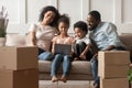 Happy black family sitting in living room with computer.