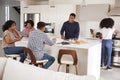 Happy African American family talking and preparing a family meal together in their kitchen