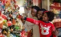Happy black family of three decorating Christmas tree at home Royalty Free Stock Photo