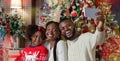 Happy black family of three taking selfie near Christmas tree