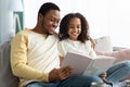 Happy black father and daughter reading book together Royalty Free Stock Photo