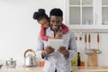 Happy black father and daughter using pad together at home Royalty Free Stock Photo