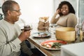 Happy black father drinking yerba mate during lunch at home - Main focus on hand