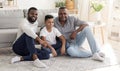 Happy black father, son and grandfather relaxing together on floor at home Royalty Free Stock Photo