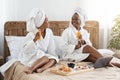 Happy black female friends having breakfast in bed Royalty Free Stock Photo